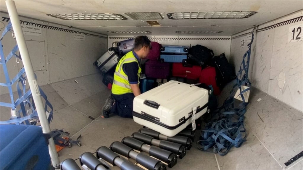 Ramp agent from stacking luggage in an aircraft hold using Power Stow’s Rollertrack Conveyor.
